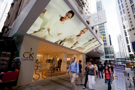 Calvin Klein retail storefront featuring mannequins, large display windows, and foot traffic in a city shopping district.